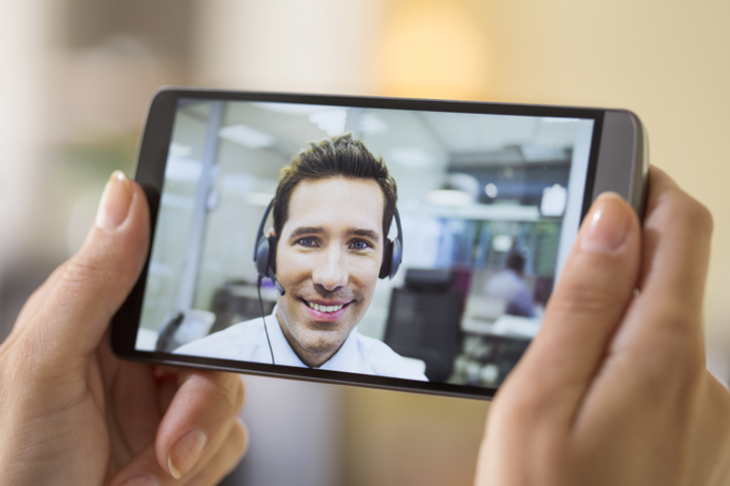 Female-hand-holding-a-smart-phone-during-a-Skype-video